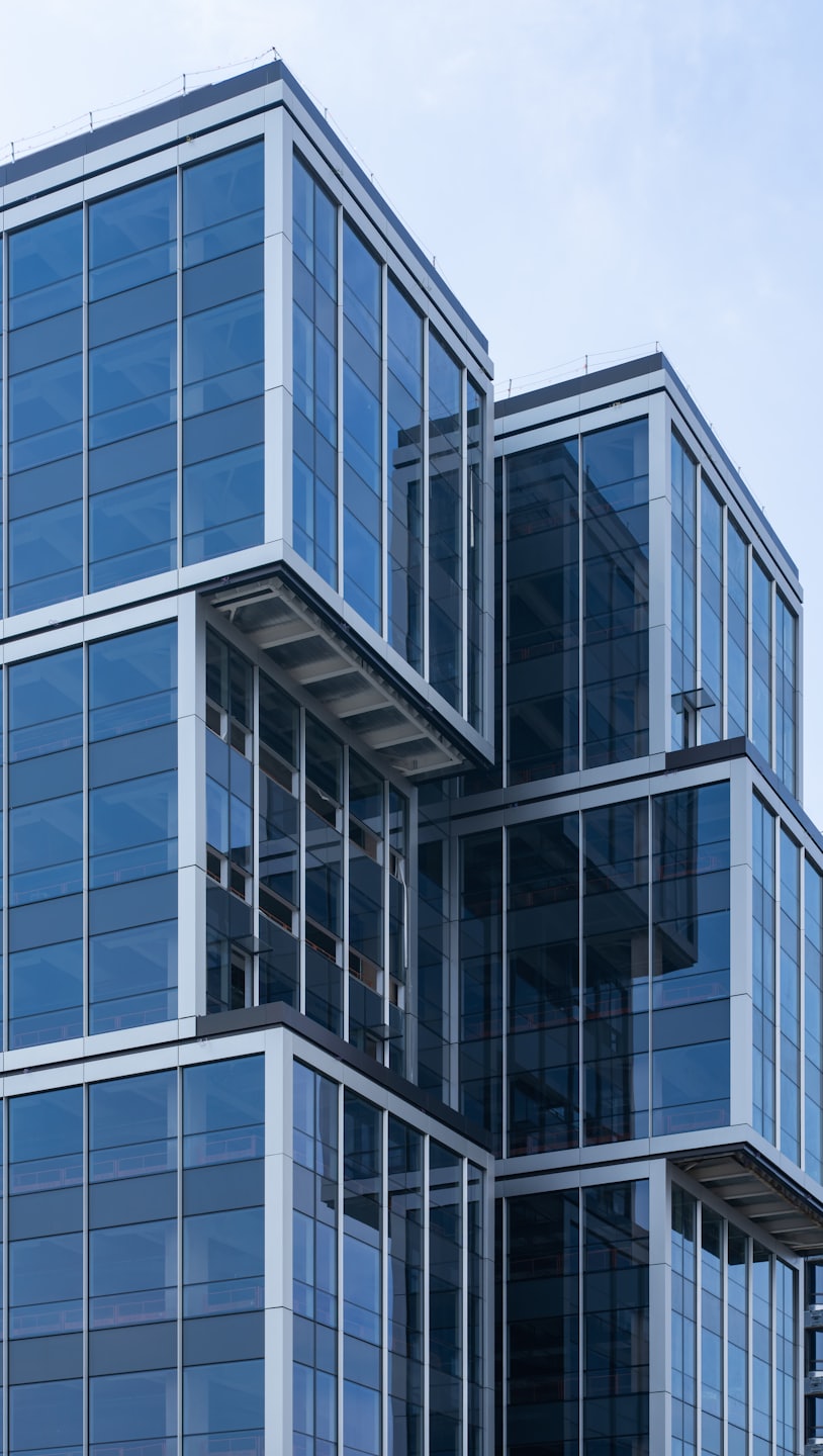 Informazioni Moderno edificio in vetro e acciaio con blocchi geometrici a sbalzo.